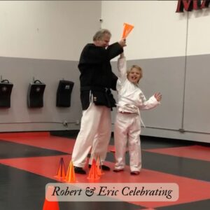 Martial arts instructor celebrating with student after completing a drill, demonstrating confidence building through structured practice