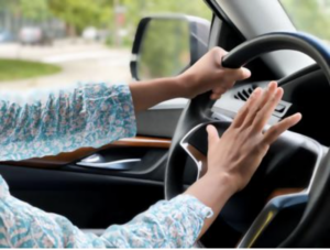 Driver angrily pressing a car horn during traffic frustration, representing emotional reactions, unresolved conflict, and carrying resentment after difficult interactions.